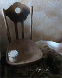 Prázdna hnedá stolička, na nej plechovka v starej izbe