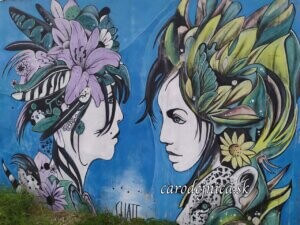 Dve ženy s kvetmi vo vlasoch na streetart